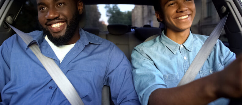 Father and teen son drive in car