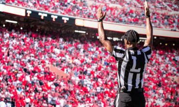 Referee signals a touchdown at a football game - car insurance in Georgia