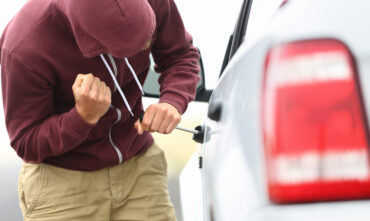 Thief attempting to break into car.
