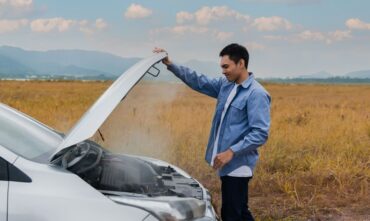 Man opens car hood because it is overheated - Southern Harvest Cheap homeowners in Georgia.