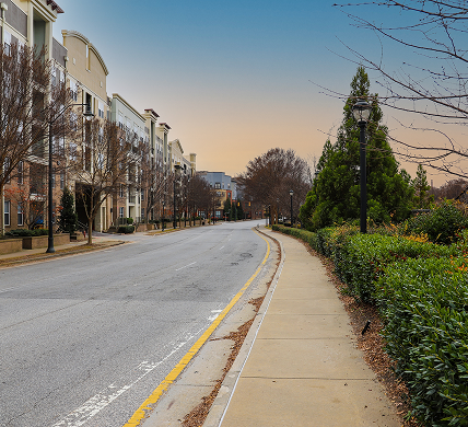 a long winding smooth street in the city surrounded by buildings and lush green and autumn colored trees and plants in downtown Atlanta Georgia.