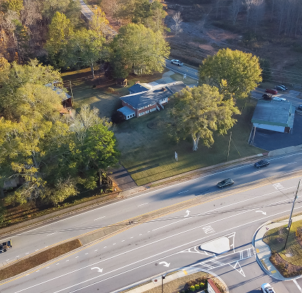 Gas station, business buildings, residential houses near busy intersection of Hamilton Mill Road, Bogan Road in Buford - cheap car insurance in Georgia.