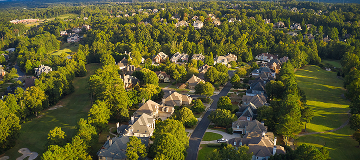 Aerial view of a tree-lined suburban neighborhood with large homes and winding streets in Milton, Georgia
