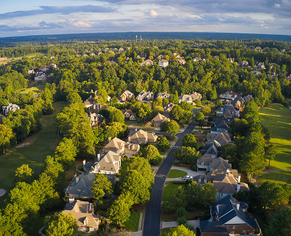 Aerial view of a tree-lined suburban neighborhood with large homes and winding streets in Milton, Georgia