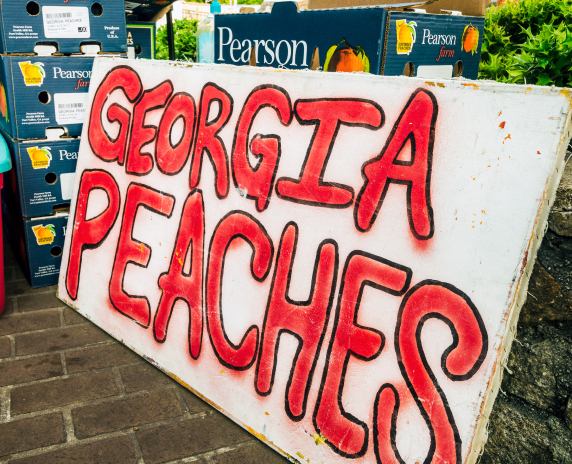 Tucker, Georgia, USA - May 22, 2014: Fresh Georgia peaches, grown in Fort Valley, Georgia are stacked for sale at the Tucker Farmers Market in downtown Tucker, Georgia.