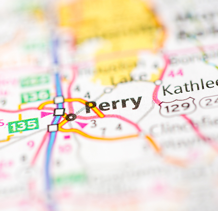 A close-up map view highlighting the city of Perry, Georgia, showing surrounding highways and nearby towns for geographic context.