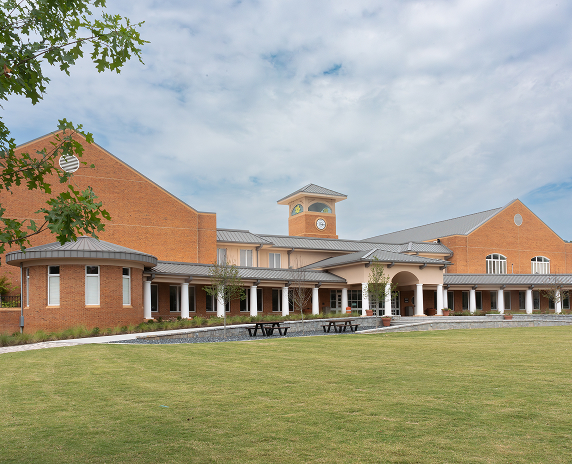Wide view of the Smyrna Community Center with red brick buildings and an open lawn in Smyrna, Georgia