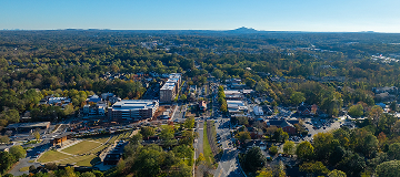 Aerial view of downtown South Fulton, Georgia with tree-lined streets, buildings, and surrounding suburban neighborhoods.